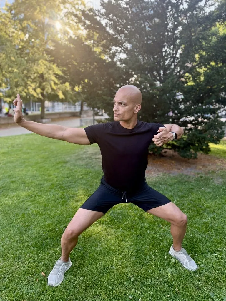 Manuel in einer Tai-Chi-Haltung im Park